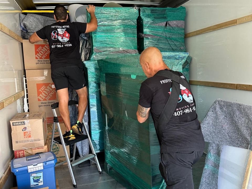 Pro Elite Movers crew loading wrapped furniture for a long-distance move